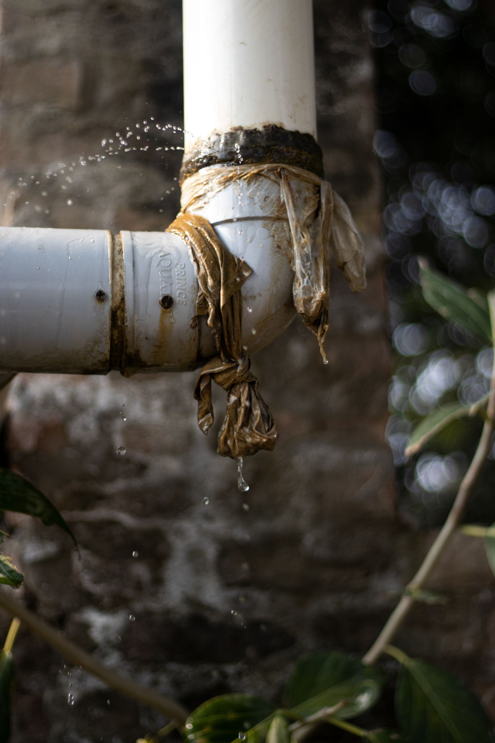 Leaking water pipe spraying water outdoors