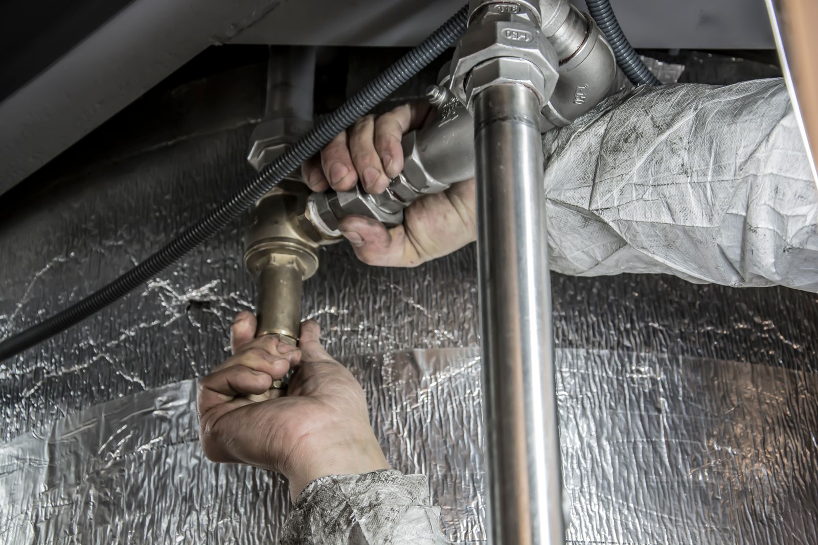 Plumber fitting steel pipes by hand
